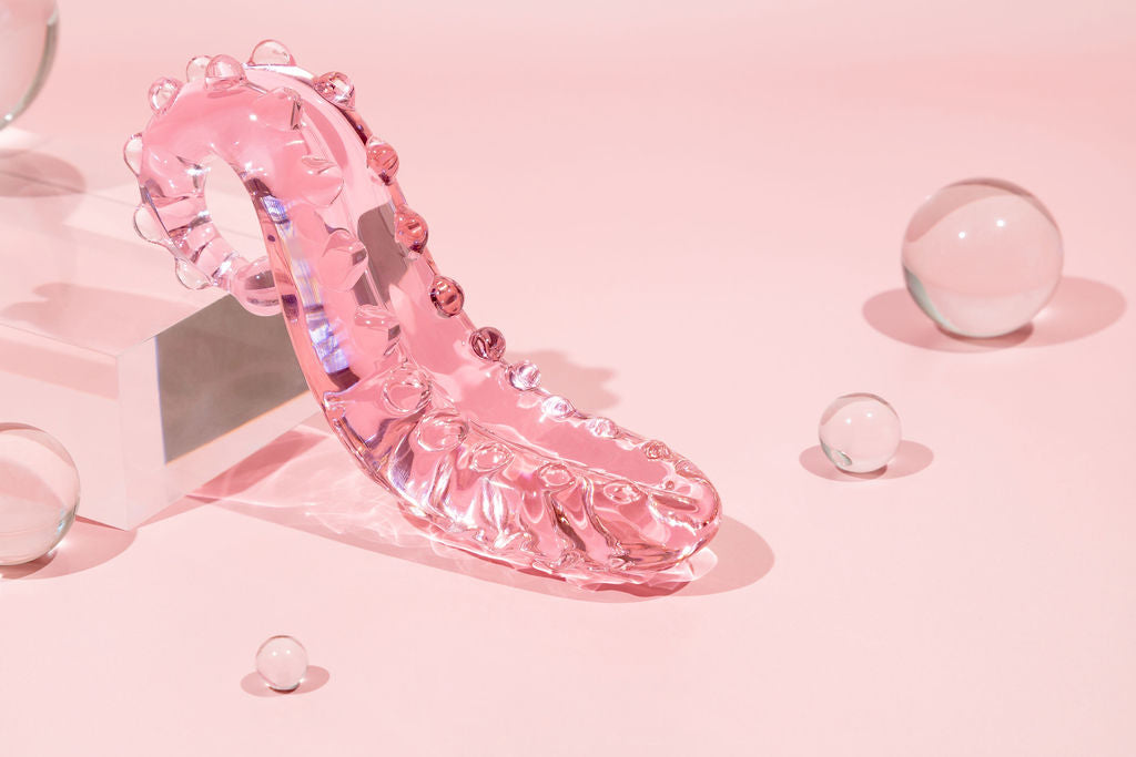 Pink Sacred Squirter. Glass Pleasure wand with ridges pictured on acrylic block with bubbles.